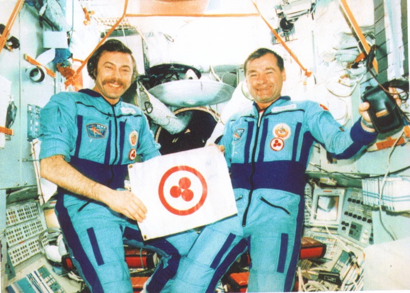 Космонавты А.Н.Баландин и Г.М.Стрекалов со Знаменем Мира (орбитальный комплекс «Мир», 1990 г.)